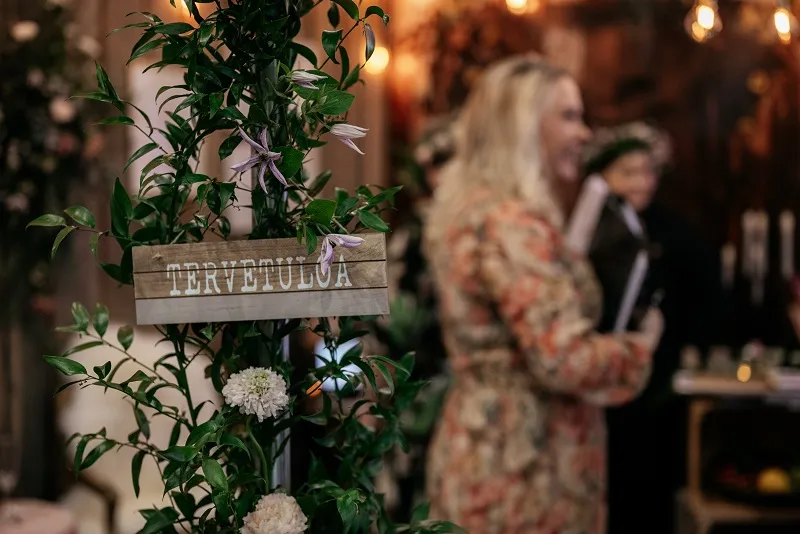Tervetuloa-kyltti viherkasvien keskellä